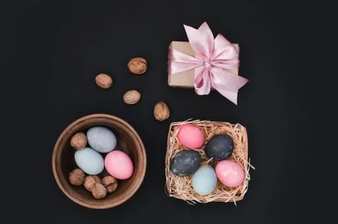 Easter greeting background with dyed multicolored chicken quail eggs on straw in Stock Photos