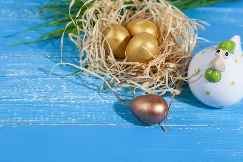 Easter greeting card. Easter chick in a nest and golden eggs. Stock Photos