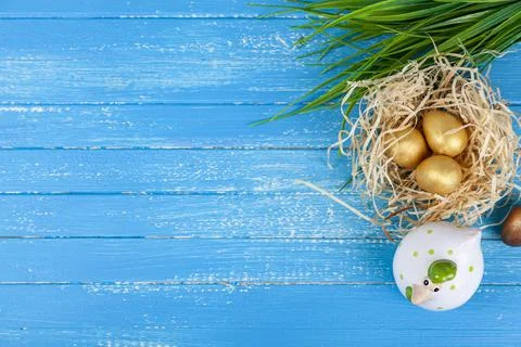 Easter greeting card. Easter chick in a nest and golden eggs. Stock Photos