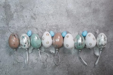 Easter greeting card with Easter eggs and feathers on a concrete background. The Stock Photos
