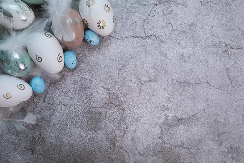 Easter greeting card with Easter eggs and feathers on a concrete background. The Stock Photos