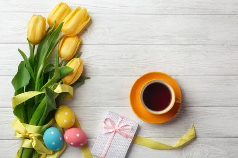 Easter greeting card with tulip flowers bouquet and easter eggs. Top view ove Stock Photos