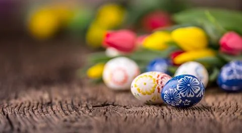 Easter. Hand made easter eggs and spring tulips on old wooden table Stock Photos