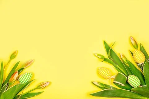 Easter hand made eggs with white tender tulips on a yellow background. Easter Stock Photos