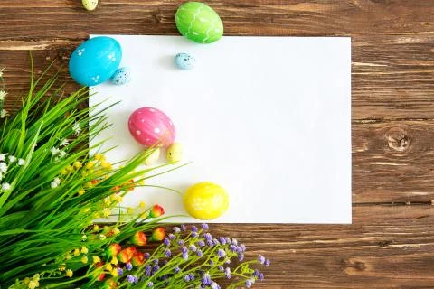 Easter holiday background with paper note, easter eggs in basket and flowers  Foto stock
