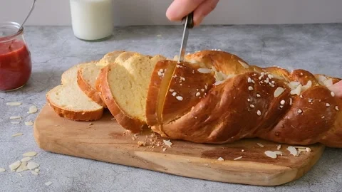 Easter holiday bread. Woman's hand cuts traditional Easter bread Stock Footage 238442978