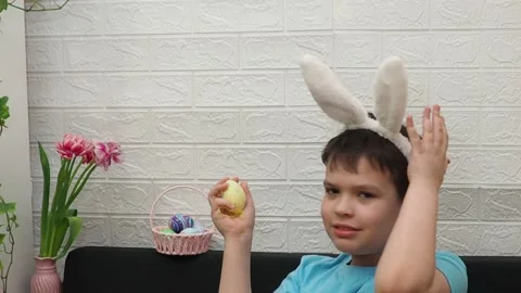 Easter holiday.  bunny ears. A boy  paints an Easter egg. Preparing for Easter 스톡 동영상 173750678