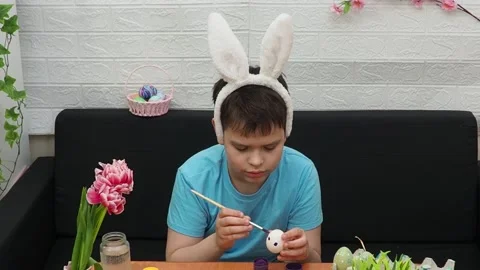 Easter holiday.  bunny ears. A boy  paints an Easter egg. Preparing for Easter 스톡 동영상 173752819