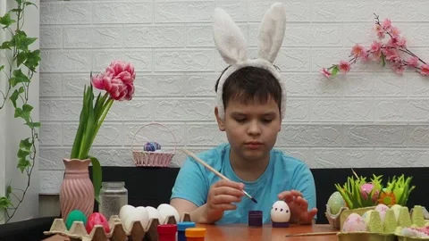 Easter holiday.  bunny ears. A boy  paints an Easter egg. Preparing for Easter 스톡 동영상 173754271