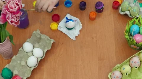 Easter holiday.  bunny ears. A boy  paints an Easter egg. Preparing for Easter 動画素材 173777658
