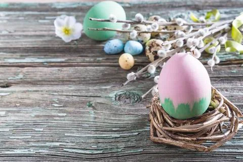 Easter holiday composition. Easter eggs and bouquet of willow twigs on old pa Stock Photos