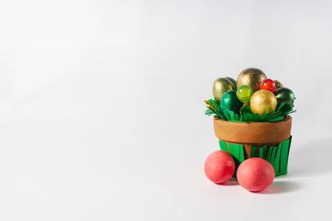 Easter holiday concept. Pot with colored eggs and sweets on a white backgroun Stock Photos