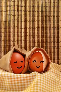 Easter Holiday Concept Two Egg Hooded Smile on a Yellow Napkin with Dark Brow Stock Photos