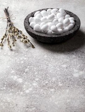 Easter holiday concept.White small eggs in a plate on a gray background. Holi Stock Photos
