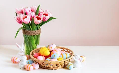 Easter holiday decorating with painted eggs in the basket on wooden table a.. Stock-Fotos