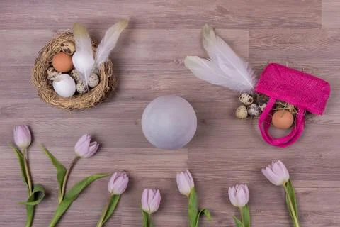 Easter holiday decoration design with eggs feathers bag tulips. Beautiful dec Stock Photos