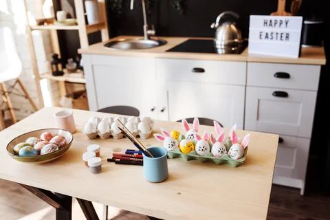 Easter holiday preparations, dyed Easter eggs, paints and brushes on the table Stock Photos