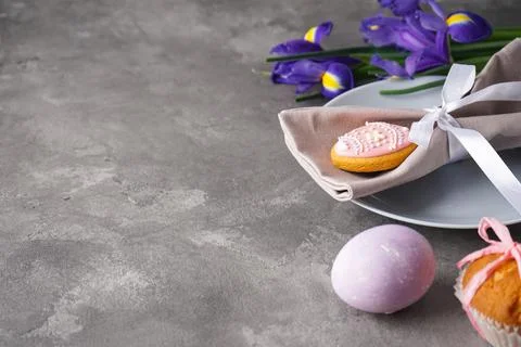 Easter holiday table setting, plates and flowers on a grey background, space  Stock-Fotos