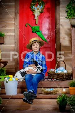 Easter holidays. Happy boy is posing on the porch of a village house. Easter Stock Photos