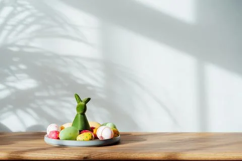 Easter home decor. Composition of Green bunny rabbit figurine and colored easter Stock Photos