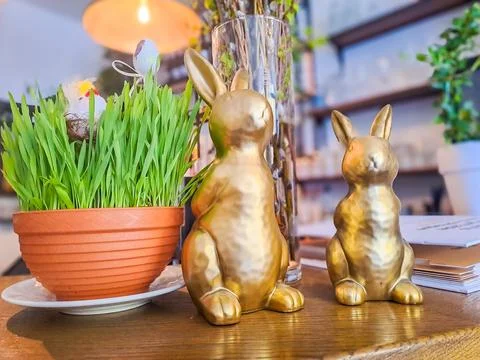 Easter home decor concept, blooming potted spring flowers standing with rabbit Stock Photos