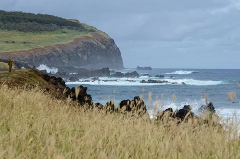 Easter Island cliffs and waves under cloudy sky Stock Photos