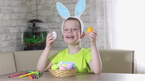 Easter kids. A happy boy with rabbit ears on his head smiles, plays at home Stock Footage 176283293