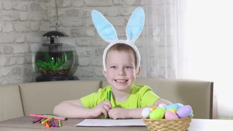 Easter kids. A happy boy with rabbit ears on his head smiles, plays at home Stock Footage 176283413