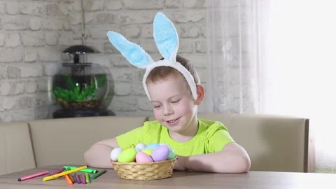 Easter kids. A happy boy with rabbit ears on his head smiles, plays at home  Stock Footage 232998357