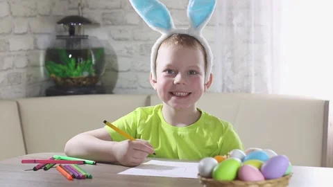 Easter kids. A happy boy with rabbit ears on his head smiles, plays at home  Stock Footage 232998406