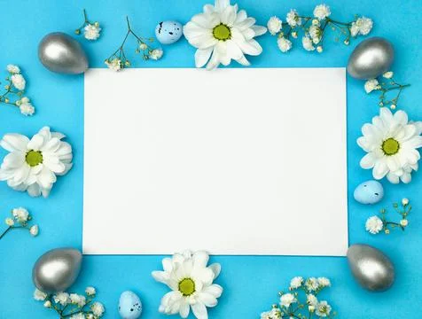Easter layout from white flowers silver eggs and blank white paper. Top view Stock Photos