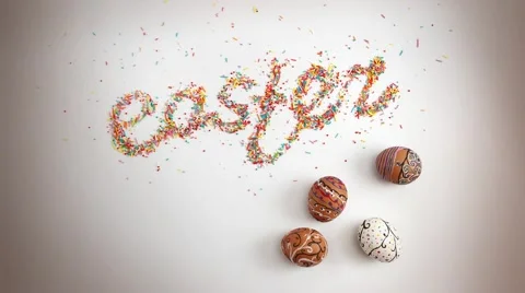 Easter lettering made of colorful baking sugar with eggs and one egg spinning Stock Footage 62298038