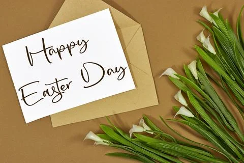 Easter lily white spring flower and paper card in envelope with text Happy Easte Stock Photos