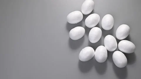 Easter. Many eggs roll of the same color, white, roll on a gray background. Top Stock Footage 150520207