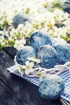 Easter marble eggs in a white bucket on the blue cloth Stock Photos