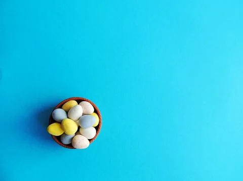Easter mini chocolate eggs on bright blue background. Stock Photos