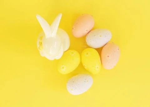 Easter minimalistic background with a ceramic rabbit and a shadow of flowers on Stock Photos