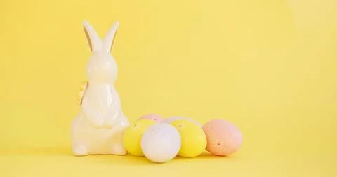 Easter minimalistic background with a ceramic rabbit and a shadow of flowers on Stock Photos