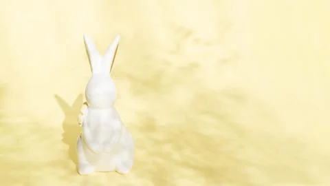 Easter minimalistic background with a ceramic rabbit and a shadow of flowers on Stock Photos