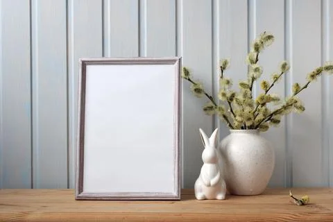 Easter mockup with an empty frame and a rabbit figurine on the table. Easte.. Foto stock