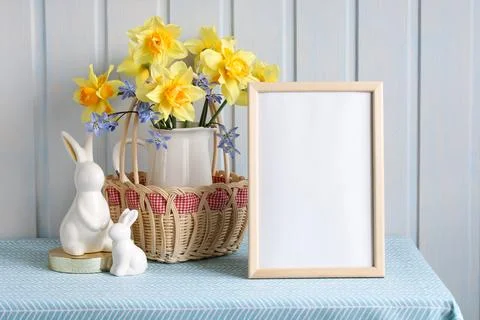 Easter mockup with an empty frame, a bouquet of garden daffodils and figure.. Foto stock