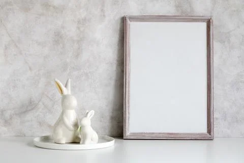 Easter mockup. an empty wooden frame and rabbit figurines. background, an emp Stock Photos