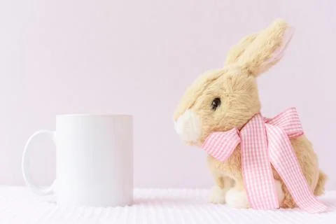 Easter mockup white mug with rabbit on pink cover background Stock Photos