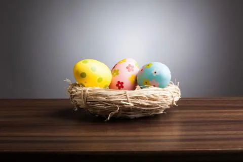 Easter nest with decoration eggs on table, gray background Stock Photos