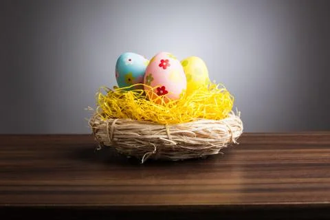 Easter nest with decoration eggs on table, gray background Stock Photos