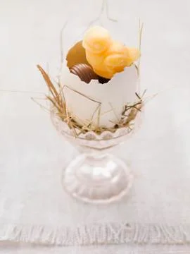 An Easter nest in an eggcup with sweets Stock Photos