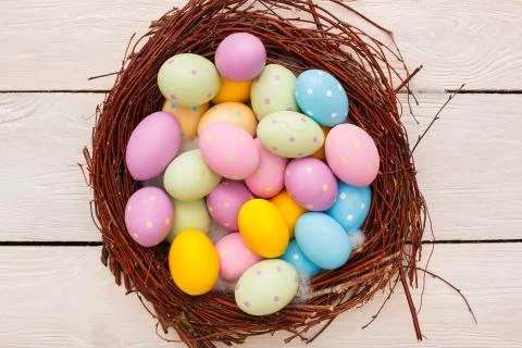 Easter objects eggs colored in dots isolated on wooden background in a nest Stock Photos
