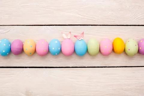 Easter objects eggs isolated on wooden background decorated with bunny ears and Stock Photos