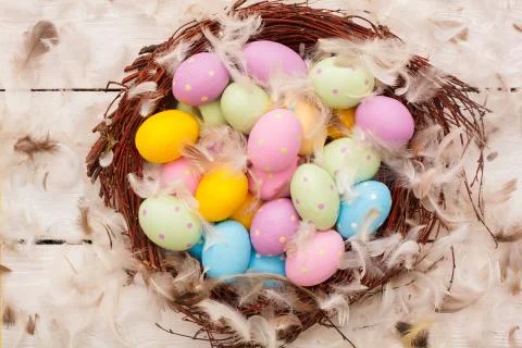 Easter objects eggs isolated on wooden background in a nest covered with Foto stock