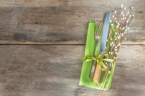 Easter or spring holiday table setting. Antique knife and fork, linen green n Stock Photos